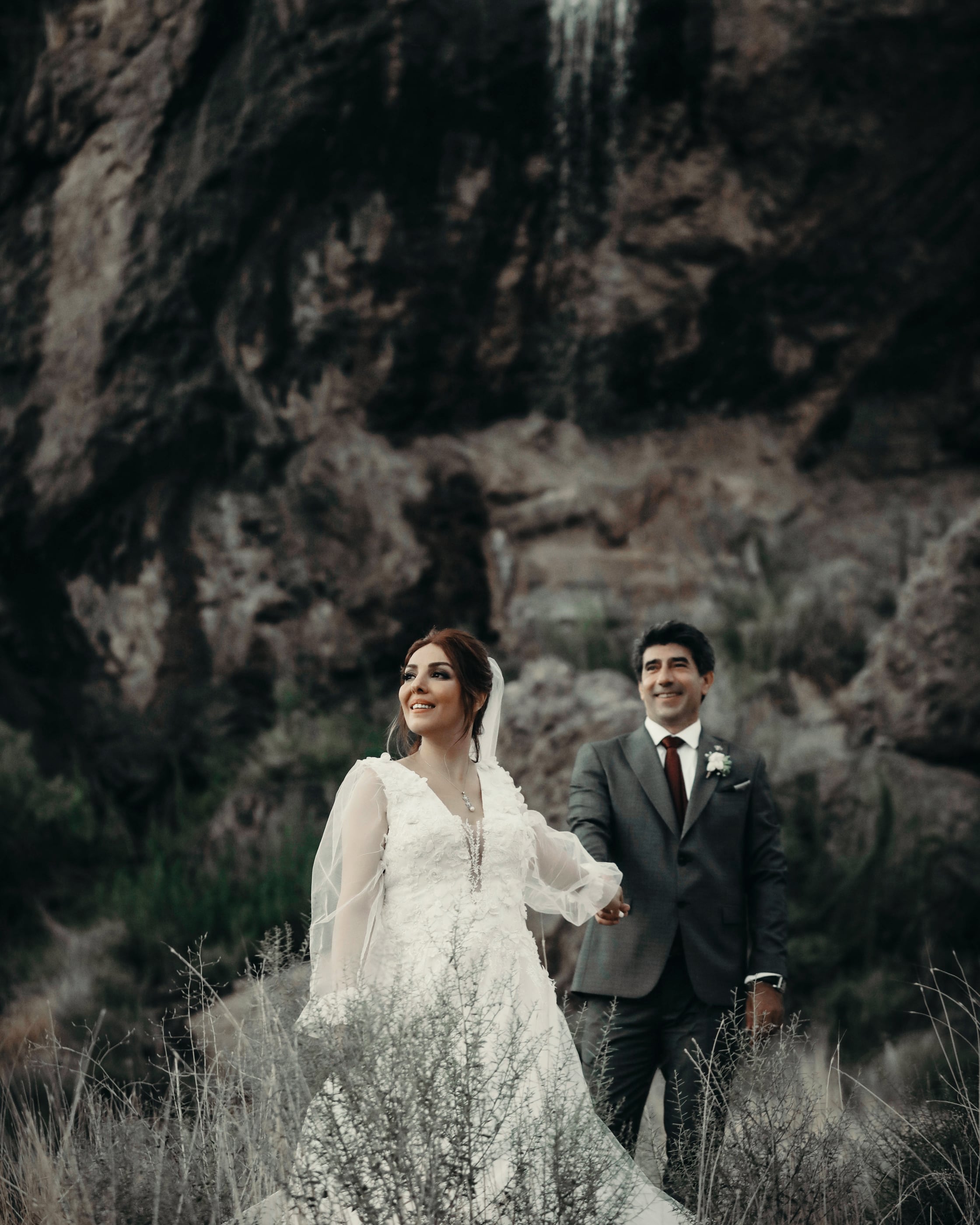 Bride and Groom Standing on Grass Field